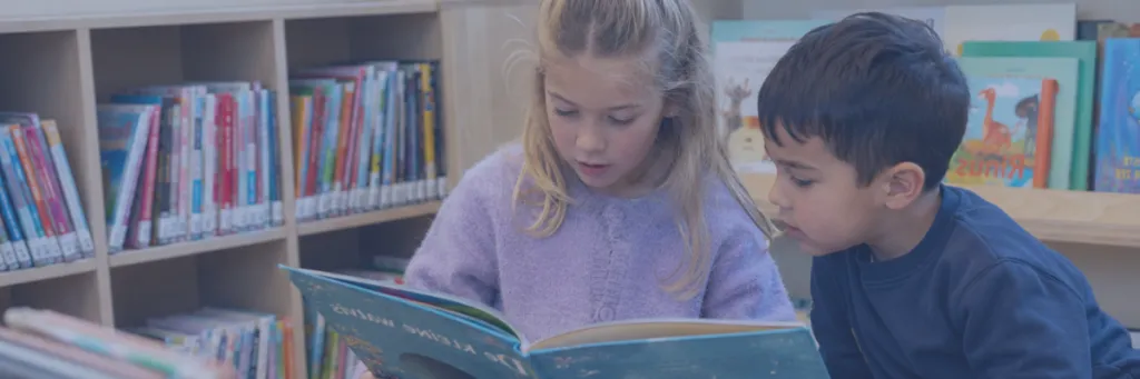 Twee kinderen lezen uit een boek